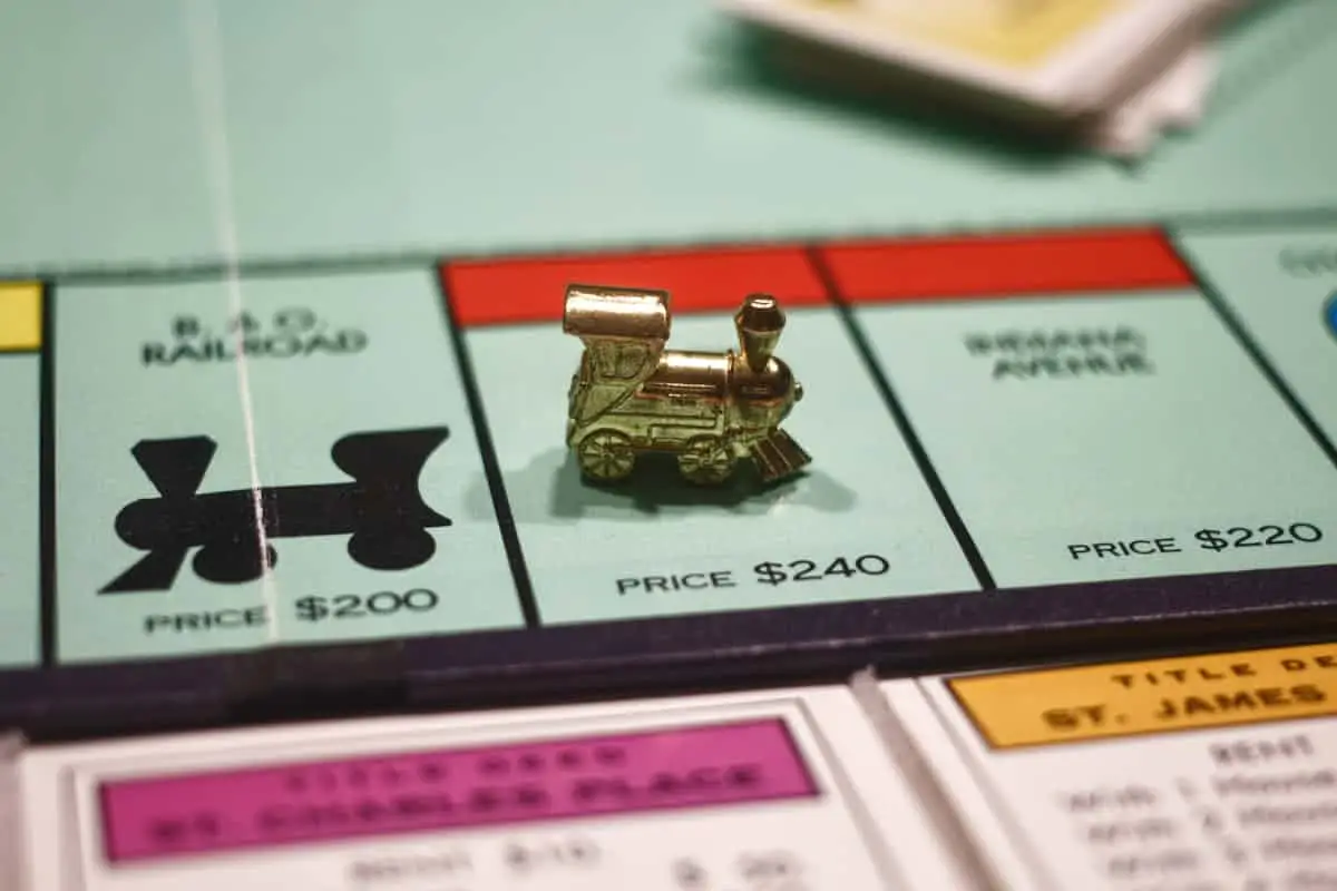 A gold train token on a Monopoly board, positioned on a red property space next to the B. & O. Railroad.